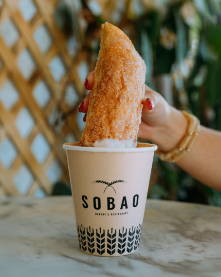 an overlayed photo of customers in the Sobao restaurant terrace